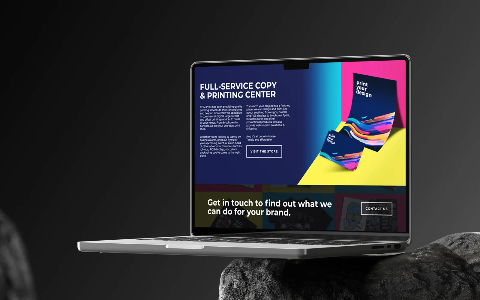 The CDM Print site on a laptop, staged on dark rock — the full-service copy and printing page.