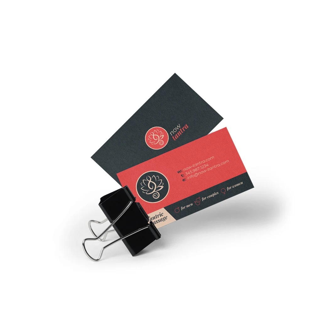 Business cards on uncoated stock — the lotus mark on charcoal, contact details on soft red.